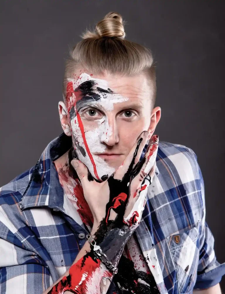 Eddy, Tätowierer aus Berlin, mit Farbe im Gesicht