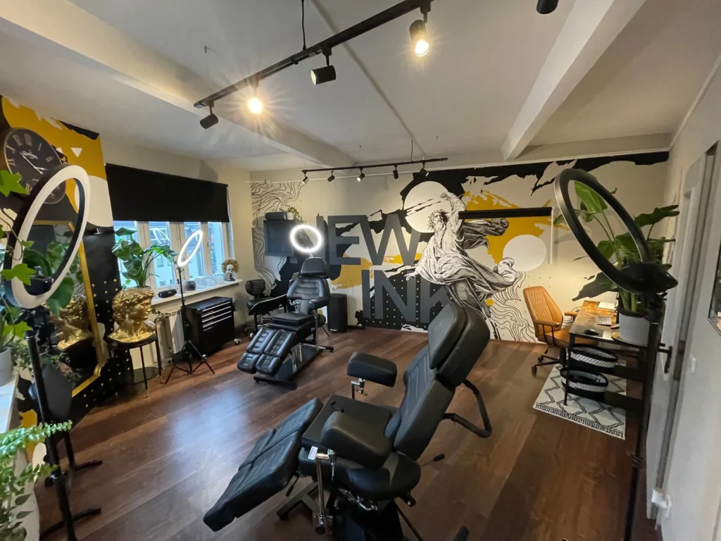 Arbeitsraum im Tattoo-Studio in Berlin-Karlshorst mit zwei Tattoo-Liegen, Ringlichtern und bemalter Wand