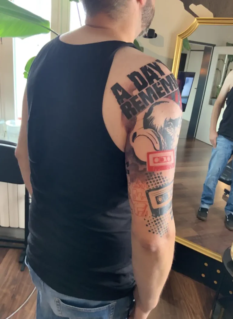 Trash-Polka-Sleeve im Entstehen, rote Vorzeichnung auf der Haut sichtbar, Schriftzug und Schimpanse teilweise gestochen