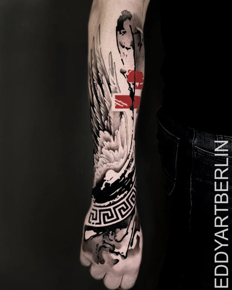 Unterarm-Tattoo mit Engelsflügel und roten Farbflächen im Trash-Polka-Stil
